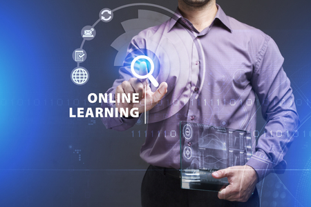 Business, Technology, Internet and network concept. Young businessman working on a virtual screen of the future and sees the inscription: Online learningの写真素材