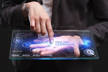 The concept of business, technology, the Internet and the network. A young entrepreneur working on a virtual screen of the future and sees the inscription: Online learningの写真素材