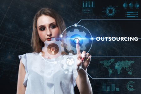 The concept of business, technology, the Internet and the network. A young entrepreneur working on a virtual screen of the future and sees the inscription: Outsourcingの写真素材