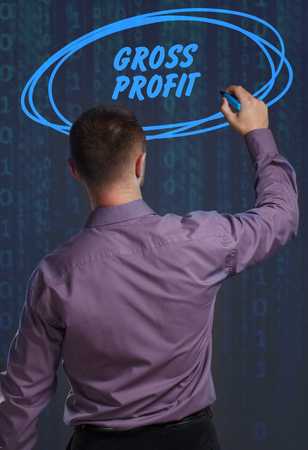 Business, Technology, Internet and network concept. Young businessman working on a virtual screen of the future and sees the inscription: Gross profitの写真素材