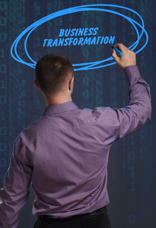 Business, Technology, Internet and network concept. Young businessman working on a virtual screen of the future and sees the inscription: Business transformationの写真素材