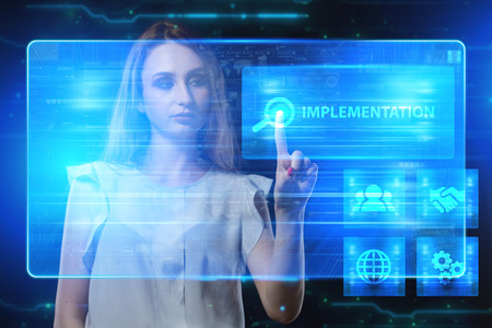 The concept of business, technology, the Internet and the network. A young entrepreneur working on a virtual screen of the future and sees the inscription: Implementationの写真素材