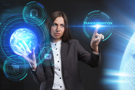 A young entrepreneur working on a virtual screen of the future and sees the inscription: Transformationの写真素材