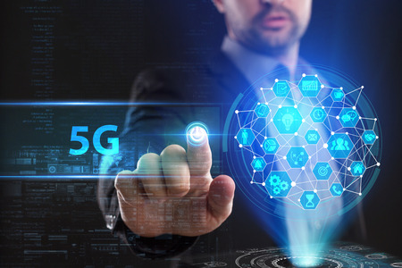 The concept of business, technology, the Internet and the network. A young entrepreneur working on a virtual screen of the future and sees the inscription: 5Gの写真素材
