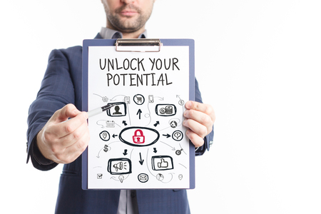 The concept of business, technology, the Internet and the network. A young businessman shows a successful scheme of work: Unlock your potentialの写真素材