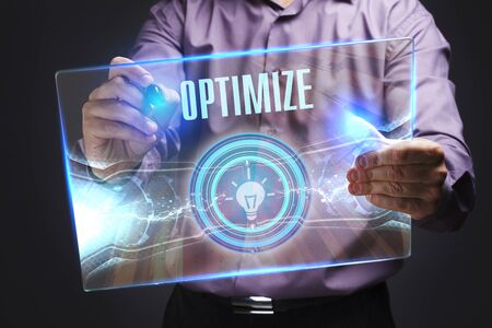The concept of business, technology, the Internet and the network. A young entrepreneur working on a virtual screen of the future and sees the inscription: Optimizeの写真素材
