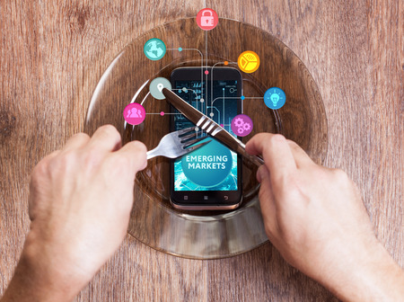 The concept of business, technology, the Internet and the network. A young entrepreneur working on a virtual screen of the future and sees the inscription: Emerging marketsの写真素材