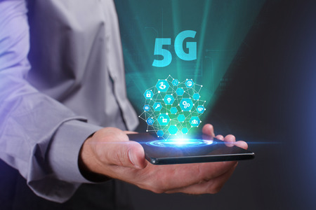 The concept of business, technology, the Internet and the network. A young entrepreneur working on a virtual screen of the future and sees the inscription: 5Gの写真素材