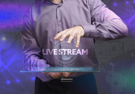 The concept of business, technology, the Internet and the network. A young entrepreneur working on a virtual screen of the future and sees the inscription: Live streamの写真素材