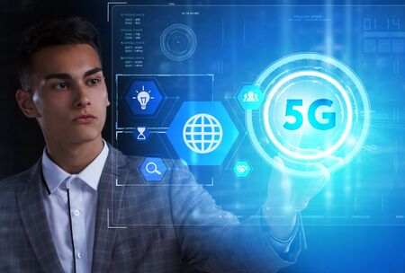 The concept of business, technology, the Internet and the network. A young entrepreneur working on a virtual screen of the future and sees the inscription: 5Gの写真素材