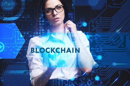 The concept of business, technology, the Internet and the network. A young entrepreneur working on a virtual screen of the future and sees the inscription: Blockchainの写真素材