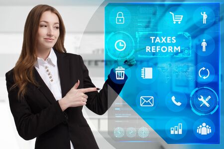Business, Technology, Internet and network concept. Young businessman working on a virtual screen of the future and sees the inscription: taxes reformの写真素材