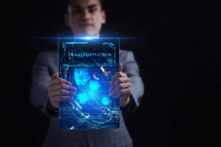 Business, Technology, Internet and network concept. Young businessman working on a virtual screen of the future and sees the inscription: Transformationの写真素材