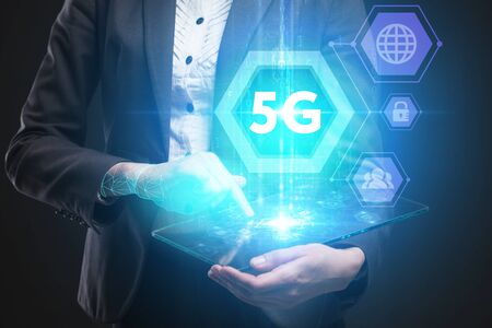Business, Technology, Internet and network concept. Young businessman working on a virtual screen of the future and sees the inscription: 5Gの写真素材