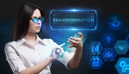 Business, Technology, Internet and network concept. Young businessman working on a virtual screen of the future and sees the inscription: Transformationの写真素材
