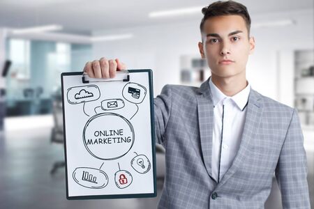 Business, Technology, Internet and network concept. Young businessman working on a virtual screen of the future and sees the inscription: Online marketingの写真素材