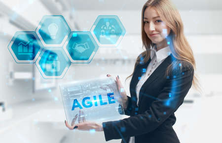 Business, Technology, Internet and network concept. Young businesswoman working on a virtual screen of the future and sees the inscription: Agileの写真素材