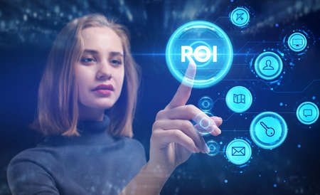Business, Technology, Internet and network concept. Young businesswoman working on a virtual screen of the future and sees the inscription: ROIの写真素材