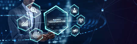 The concept of business, technology, the Internet and the network. A young entrepreneur working on a virtual screen of the future and sees the inscription: Business transformationの写真素材