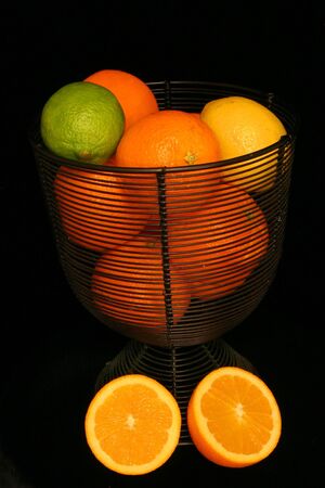 Citrus Fruit in a Basket Over Blackの写真素材