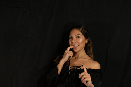 latina woman posing on camera with black backgroundの写真素材