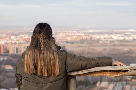 Woman on her back leaning on a wooden railing looking at viewsの写真素材