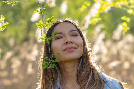 Latina Woman with Closed Eyes Enjoying Nature Peacefullyの写真素材