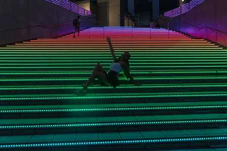 Silhouette of Young Woman on Colorful Lighted Stairs