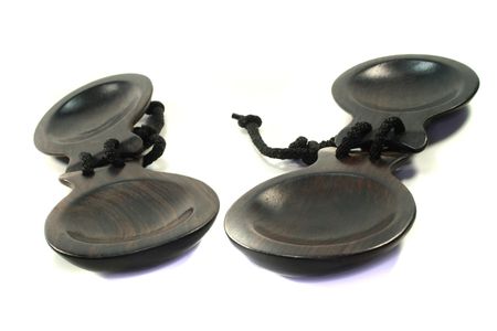 two brown wooden castanets on a white backgroundの写真素材
