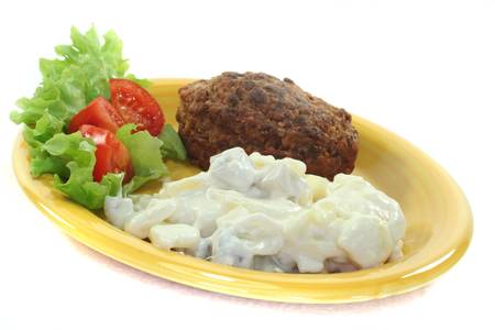 Meatball with potato salad, fresh lettuce and tomato pieces