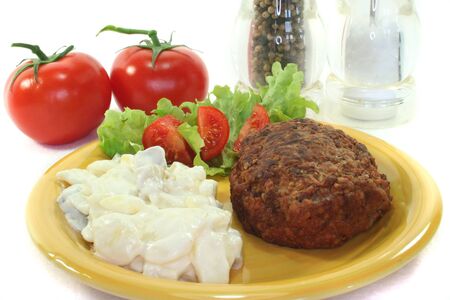 Meatball with potato salad, fresh lettuce and tomato piecesの写真素材