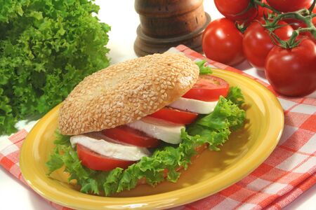 Sesame bagel with tomatoes, mozzarella and basil