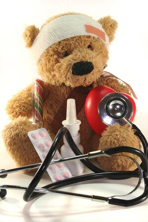 injured Teddy child with doll doctor on a white backgroundの写真素材