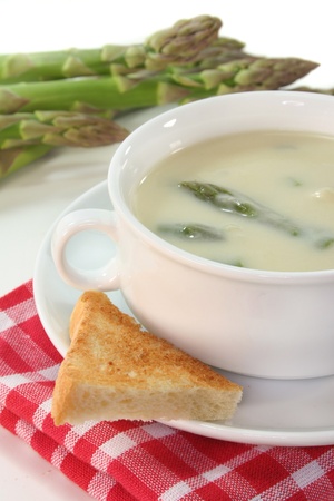 Asparagus cream soup with fresh asparagus and a slice of toastの写真素材
