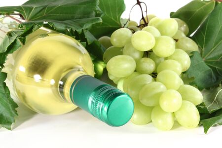 bottle of white wine with grapes and vine tendril on a white backgroundの写真素材