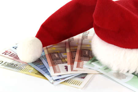 red and white Santa Claus hat on a stack of Euro notesの写真素材