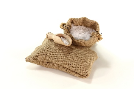 Sea salt in a bag with salt grains on the bushelの写真素材