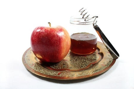 Honey jar with apple on a colorful plateの写真素材