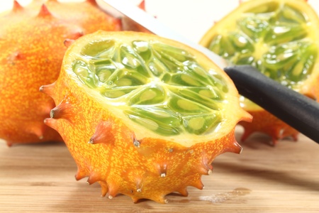 fresh sliced orange Kiwano on a wooden boardの写真素材