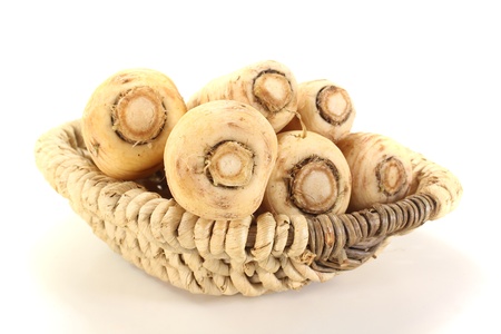 fresh beige parsnip in a basket on a light backgroundの写真素材