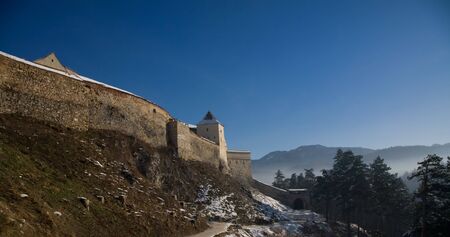 Old castle over blue sky and mountains, Rasnov, Romania, Transylvania area の写真素材