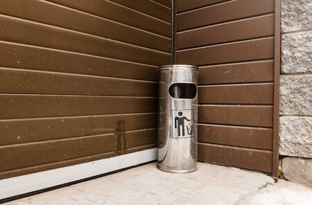 Street metal trash with an ashtray standing in the corner near the building with a bottom angleの写真素材