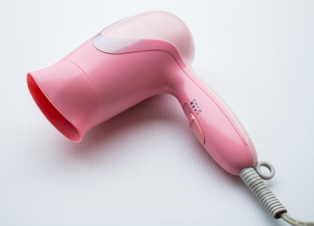 Small pink hairdryer isolated on white backgroundの写真素材