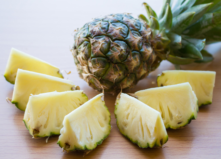 Pineapple slices on wood tableの写真素材