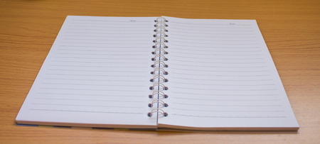 open spiral notebook on wood background