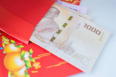 Chinese New Year red envelope with banknotes placed on a white background given to children and elders during chinese new year for blessingの写真素材