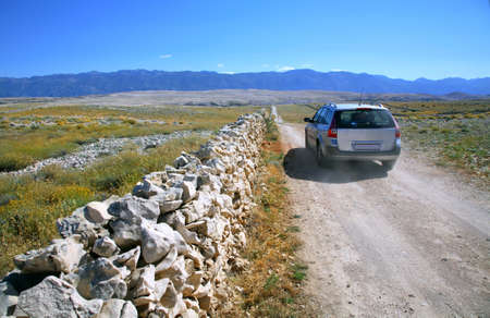 Sandy road from the main road leading to the beach called ZrÄe on the island of Pag and car is heading in direction of a beach.の写真素材