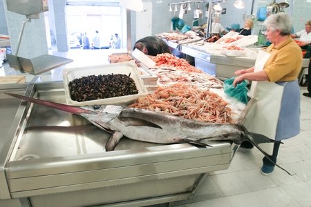 VIGO,SPAIN - May 12:Fish market, seller is preparing fish for sale at the booth full of fresh fish on May 12. 2005 in Vigo,Spain. A fish market is a marketplace used for marketing fish products.のeditorial素材