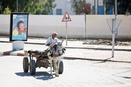 Kairouan, Tunisia -  September 16th, 2012   A man rides in a carriage on the streets of the Kairouan, Tunisia  Carriage is the usual transport in Tunisia, because of the poverty of the population of Tunisia のeditorial素材