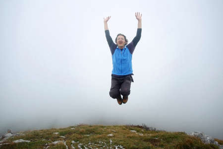  A man spreading hands and jumping on top of the mountain called Grobnicke Alpe in Grobnik, Rijeka,...